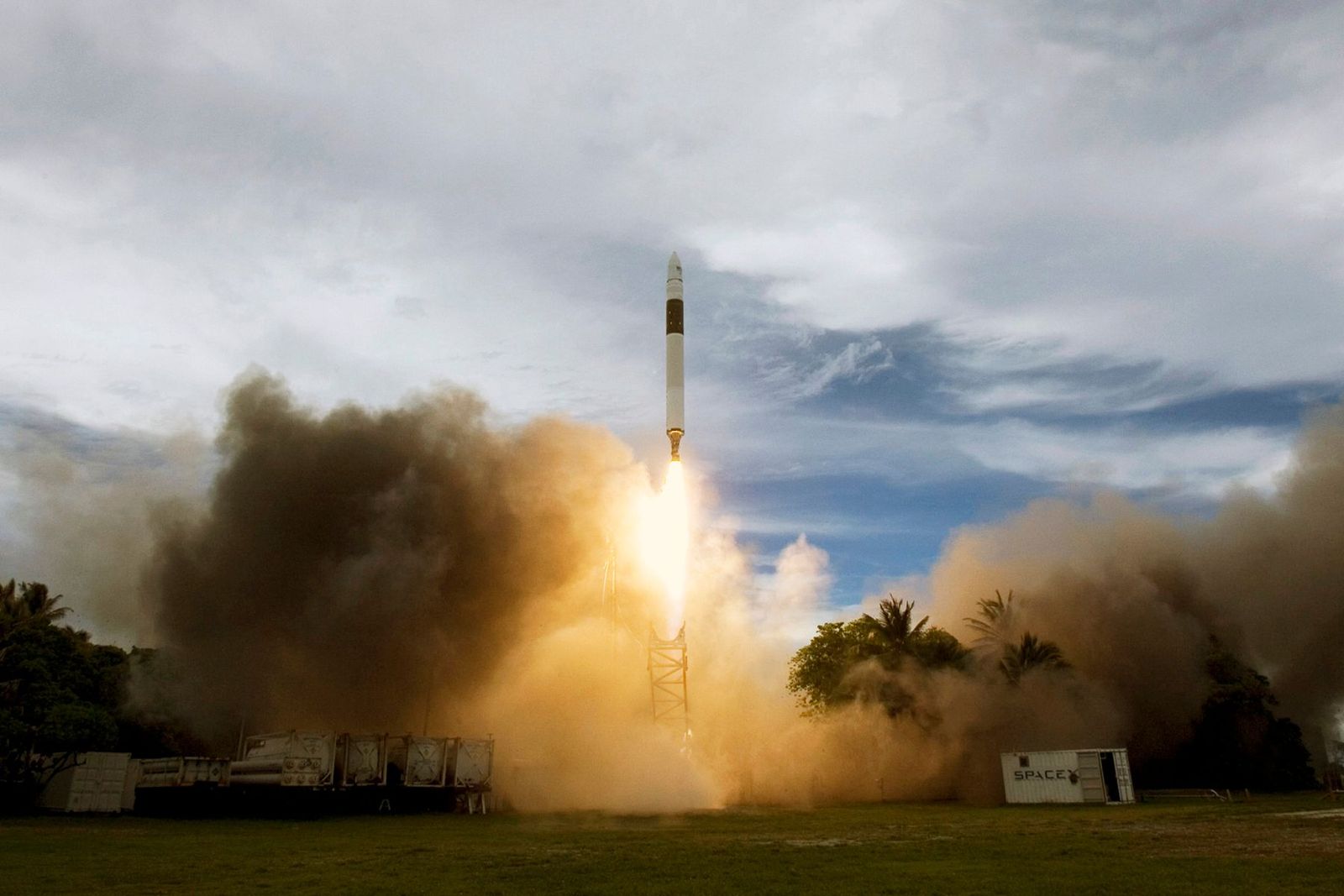 A rocket lifting off from the launch pad through clouds of exhaust